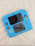 Blue handheld gaming console on a fluffy white surface